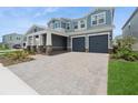 Attractive two-story home featuring a large driveway, a two-car garage, and charming stone columns on the front porch at 13187 Telsen St # 38, Winter Garden, FL 34787