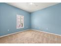 Bright bedroom with blue walls, neutral carpet, and a window with plantation shutters at 187 Tall Pines Pass, Kissimmee, FL 34759