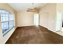 Spacious living room with large windows, neutral paint, carpeted floors, and arched doorway at 1931 N Portillo Dr, Deltona, FL 32738