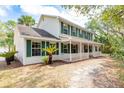 Beautiful two-story home with a large front porch, surrounded by lush greenery and mature trees at 2320 Red Ember Rd, Oviedo, FL 32765
