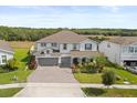 Beautiful two-story home featuring a three car garage, manicured landscaping and pond view at 2431 Knoll Dr, Apopka, FL 32712