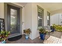 Charming front porch with a decorative front door, seating, and planters at 2431 Knoll Dr, Apopka, FL 32712