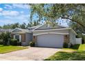 Cozy single-story home with a two-car garage, stone accents, an arched entryway and nice landscaping at 3436 Gerber Daisy Ln, Oviedo, FL 32766