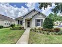 Charming single-story home featuring a well-manicured lawn and lush landscaping at 402 Ravenshill Way, Deland, FL 32724