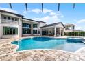 A luxurious backyard with an inviting pool, jacuzzi, covered patio, and meticulously designed outdoor living space at 4065 Isabella Cir, Windermere, FL 34786
