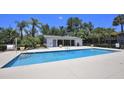 Community pool with bright blue water, lush landscaping, and bright blue sky at 4749 S Texas Ave # 4749B, Orlando, FL 32839