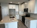 Bright kitchen featuring white cabinetry, quartz countertops, stainless steel appliances, and a central island with a sink at 5113 Prairie Preserve Run, St Cloud, FL 34772