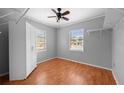 Neutral bedroom with hardwood floors, ceiling fan, white wardrobe, and dual windows for great natural light at 1010 Timor Ave, Orlando, FL 32804