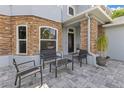 Cozy front patio with outdoor seating and stone accents provides a welcoming entrance to the home at 10142 Hidden Dunes Ln, Orlando, FL 32832