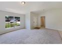 Bright living room featuring neutral paint, carpet, and a large window at 131 Pecan Pass, Ocala, FL 34472