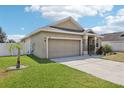 Attractive single-story home with a neat lawn, concrete driveway, and attached two-car garage at 140 Highland Meadows St, Davenport, FL 33837