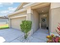 Inviting entryway with a covered porch and a two-car garage and well manicured landscape at 140 Highland Meadows St, Davenport, FL 33837
