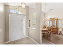 Bright foyer with a tiled floor, a white front door, and an adjacent formal dining area at 144 Henue Ct, Davenport, FL 33896