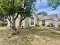 Inviting single-story home with mature tree, arched window, and attached garage, set on a green lawn at 1449 Amanda Rd, Kissimmee, FL 34744