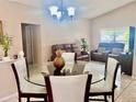 Open-concept living room showcasing a glass dining table and leather reclining sofas for relaxation and entertainment at 1449 Amanda Rd, Kissimmee, FL 34744