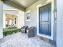Inviting front porch with seating area leading to front door of home at 15959 Pantuso Aly, Winter Garden, FL 34787