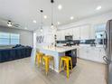 Bright, open kitchen with an island, modern lighting, stainless appliances, and breakfast bar seating at 15959 Pantuso Aly, Winter Garden, FL 34787
