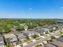 Beautiful aerial view of a residential neighborhood with lush green trees and a sparkling lake in the distance at 17226 Hickory Wind Dr, Clermont, FL 34711