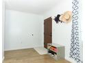 Bright foyer with light wood flooring, a white rug and walls and storage bench by the front door at 205 Sanora Blvd, Sanford, FL 32773