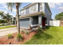 Beautiful home featuring a two-car garage, well-manicured lawn, a palm tree, and a vibrant red front door at 2117 Stone Abbey Blvd, Orlando, FL 32828