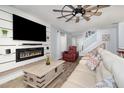 Comfortable living room features a modern fireplace, mounted TV, plush sofa, and ceiling fan at 2117 Stone Abbey Blvd, Orlando, FL 32828