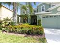 Inviting two-story home with lush landscaping featuring vibrant flowers, adding to the curb appeal at 2842 Balforn Tower, Winter Garden, FL 34787