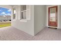 Welcoming front porch with brick pavers, white shutters, and a red front door at 3017 Ambersweet Pl, Clermont, FL 34711