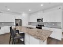 Bright kitchen features granite counters, stainless steel appliances, and a large island with seating at 3017 Ambersweet Pl, Clermont, FL 34711
