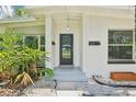 Close up of the home's white brick facade, dark front door, and well-kept landscaping at 318 E Jersey St, Orlando, FL 32806