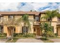 Charming tan townhome with shutters, palm trees, and well-maintained brick-paved driveway at 3643 Calabria Avenue, Davenport, FL 33897