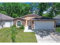 Charming single-story home with a two-car garage, stone accents, and a well-manicured lawn at 3795 Rachel St, Apopka, FL 32703