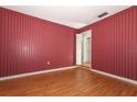 Empty bedroom with striped wallpaper and light wood flooring at 4141 Fallwood Cir, Orlando, FL 32812