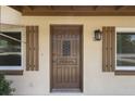 Inviting front door with decorative glass panel, sidelight windows and dark wooden shutters at 891 N Wayman St, Longwood, FL 32750