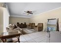 Living room with tile flooring, ceiling fan, comfortable seating, and natural light at 917 Royal Oak Blvd, Leesburg, FL 34748