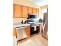 Updated kitchen features stainless steel appliances, granite counters, and stylish wood-look flooring at 963 Stucki Ter, Winter Garden, FL 34787
