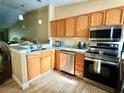 Modern kitchen boasts stainless steel appliances, granite countertops, and wooden cabinets at 963 Stucki Ter, Winter Garden, FL 34787