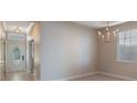 Bright dining area featuring an elegant chandelier, neutral walls, and a view of the entry foyer at 10097 Lake District Ln, Orlando, FL 32832