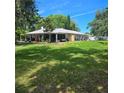 Expansive backyard with lush lawn, mature trees and a white home exterior at 1010 Bolton Rd, New Smyrna Beach, FL 32168