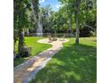 Serene pond with a fountain and a charming seating area, surrounded by lush greenery at 1010 Bolton Rd, New Smyrna Beach, FL 32168