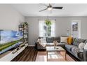 Cozy living room featuring a comfortable gray sofa, a modern TV stand, and natural lighting at 10255 Hartford Maroon Rd, Orlando, FL 32827