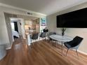 Contemporary living and dining area with hardwood floors, kitchen access, and modern table, perfect for entertaining at 109 Oyster Bay Cir # 120, Altamonte Springs, FL 32701