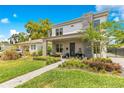 Beautifully landscaped front yard leading to a home with a stone chimney accent and an inviting covered porch at 1127 W Harvard St, Orlando, FL 32804
