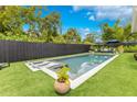 A stunning backyard featuring a modern pool, lush landscaping, and stylish outdoor seating with dual umbrellas at 1127 W Harvard St, Orlando, FL 32804