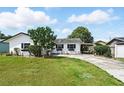 Charming single-story home with white exterior, dark shutters, and a spacious front yard at 114 Floral Dr, Kissimmee, FL 34743