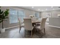 Elegant dining room with large window, round table, seating for six, and decorative art at 1204 Howell Creek Dr, Winter Springs, FL 32708