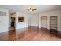 Open-concept living room with hardwood floors, shelving, and an opening to the kitchen at 122 Vista Verdi Cir # 236, Lake Mary, FL 32746