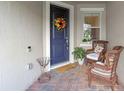 Cozy porch with seating, a colorful wreath on a blue door, and a 'Welcome' doormat at 13993 Tarvin St, Orlando, FL 32832