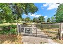 Metal gate adorned with 'Galloping Goats Ranch' and bat decorations, leading to a home at 2299 Nw 135Th Ln, Citra, FL 32113