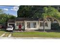 Charming single-story home featuring a red front door and a driveway with a parked car at 2312 Corrine Dr, Orlando, FL 32803