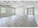 Spacious living room boasts a decorative tray ceiling, fan, and wood-look flooring at 278 Acorn Dr, Longwood, FL 32750